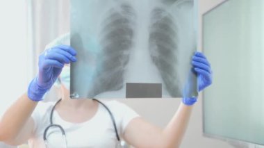Kadın doktor, florografiyi inceliyor. Kadın pulmonolog akciğerlere bakıyor. İltihaplı bir hastanın teşhis kliniği. tomografi dolabı. Hastane ya da poliklinik röntgeni