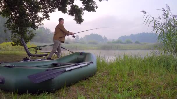 Balıkçı Elinde Dönen Balık Tutan Bir Çubukla Gölün Kenarında Duruyor — Stok video