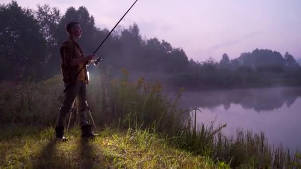 Silueta Muže Mladý Rybář Stojí Otočným Rybářským Prutem Jezera Ten — Stock video