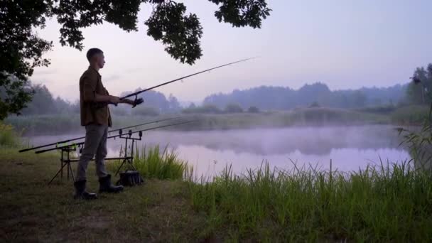 Silhuett Man Ung Manlig Fiskare Står Med Ett Snurrande Fiskespö — Stockvideo