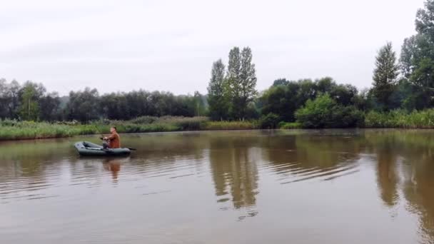 Молодой Человек Надувной Лодке Садится Бросает Воду Середине Озера Реки — стоковое видео