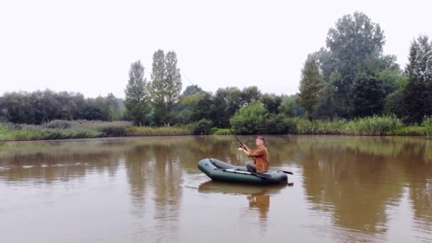 Joven Barco Inflable Sienta Lanza Una Caña Montar Pescar Agua — Vídeos de Stock