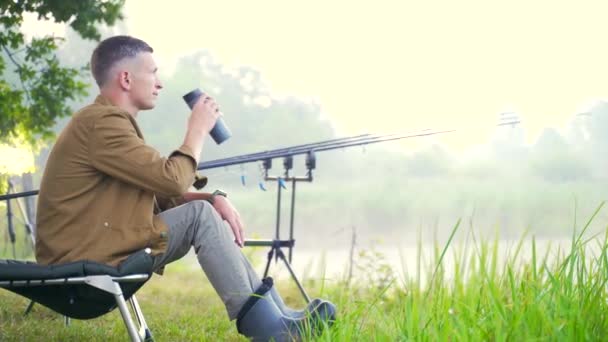 Jovem Pescador Elegante Cara Sentado Uma Cadeira Pesca Beber Uma — Vídeo de Stock