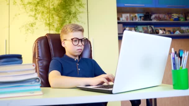 可爱的青少年在家里用笔记本电脑和课本 男孩在网上学习 在房间用电脑做作业 — 图库视频影像