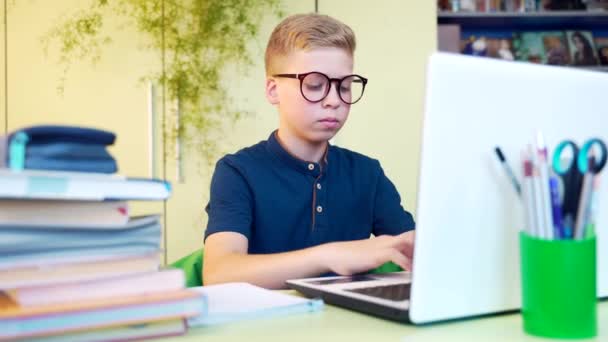 귀여운 남학생 탁자에 노트북으로 과제를 가르친다 안경을 집에서 디지털 태블릿을 — 비디오