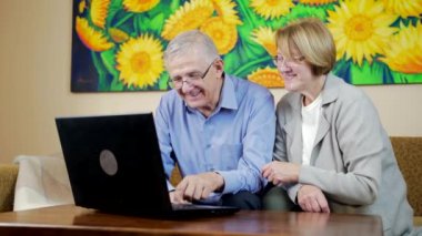 Sevimli, gülümseyen yaşlı çift dizüstü bilgisayar kullanıyor ve klavyeye yazı yazıyor. Sonra da izole edilmiş Durin karantinasında birbirlerine bakıyorlar. İnternette bir şeyler arayan mutlu büyükanne ve büyükbaba..