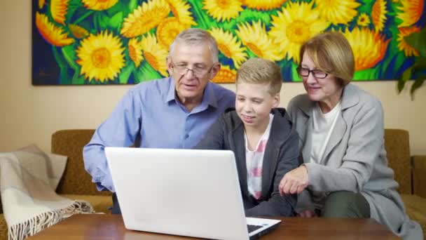 Dziadkowie Uśmiechający Się Korzystający Laptopa Wnukami Salonie Starsze Pokolenie Uczy — Wideo stockowe