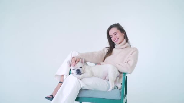 Joyeux Jeune Femme Pull Tricoté Pantalon Blanc Assis Sur Chaise — Video