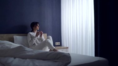 Sabahları genç bir kadın yatakta uzanıyor ve kahve içiyor. Telefondaki mesajlara bakıyor. Kadın uyanır ve evinde bir bardak sıcak içecekle akıllı telefonuna bakar.