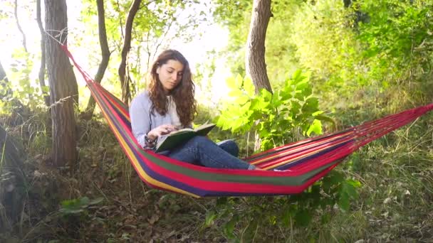 Charmig Ung Dam Med Mörkt Hår Ligger Färgglada Hängmatta Sommarparken — Stockvideo