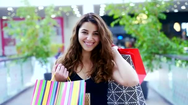 Charming Young Lady Dark Hair Jumping Joy Colorful Bags Hands — Stock Video