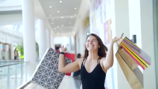 상점에서 성공적으로 쇼핑을 머리카락을 여자가 가방을 즐거움으로 뛰어오르고 지상주의와 구매의 — 비디오