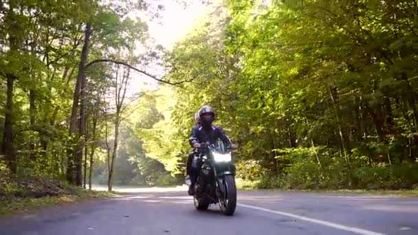 Jong paar rijdt een motorfiets op een bos weg — Stockvideo
