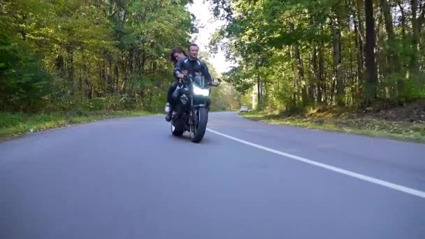 Młoda para jeździ motocyklem po leśnej drodze — Wideo stockowe