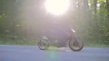  Genç çift ormanda motosiklet sürüyor.