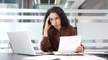 İş yerindeki bir masada otururken evrak işleriyle kafası karışmış bir iş kadını. Finansal sonuçlardan ve kötü göstergelerden memnun olmayan hayal kırıklığına uğramış kadın finansör