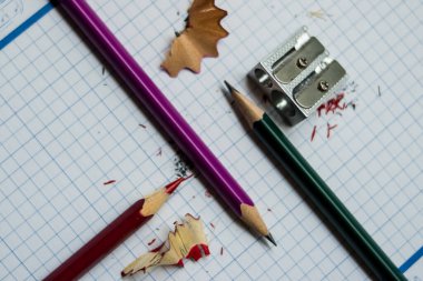 Mavi ve beyaz bir defterde farklı kalemler