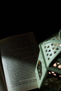 Masadaki eski bir kitabın üzerindeki eski yeşil fener.
