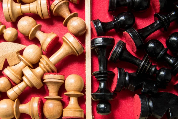 Wooden chess tokens in a red box