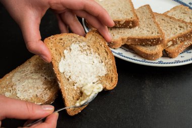 Tahta bir masada tereyağlı tam yağlı ekmek.
