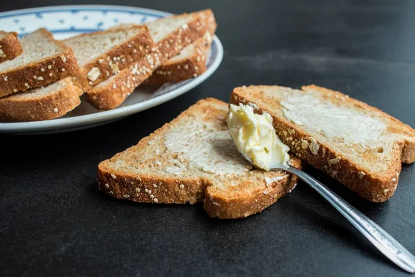 Etwas Vollkornbrot Mit Butter Auf Einem Teller Auf Einem Dunklen — Stockfoto