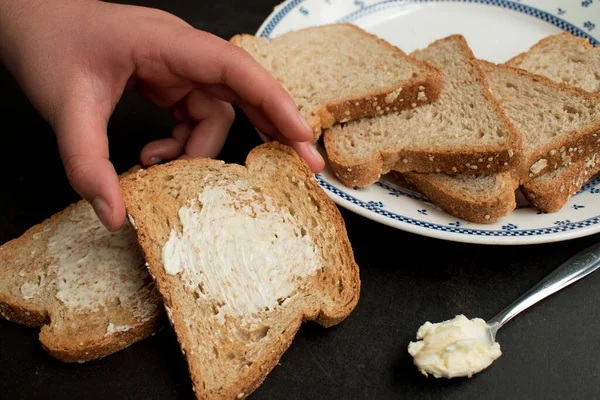 Algum Pão Integral Com Manteiga Uma Chapa Uma Mesa Escura — Fotografia de Stock