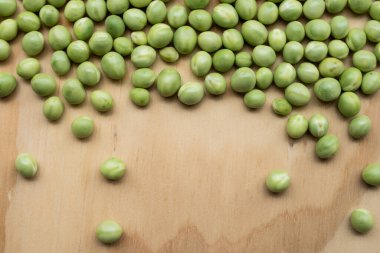 Kahverengi ahşap masadaki yeşil, taze kolyeler. 