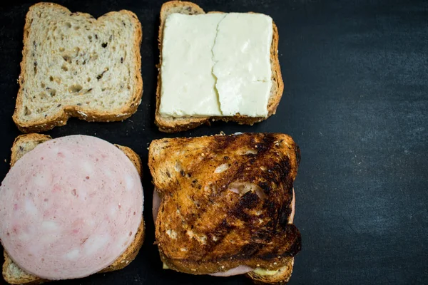 濃い木製のテーブルの上にジャムとチーズの新鮮なサンドイッチ — ストック写真