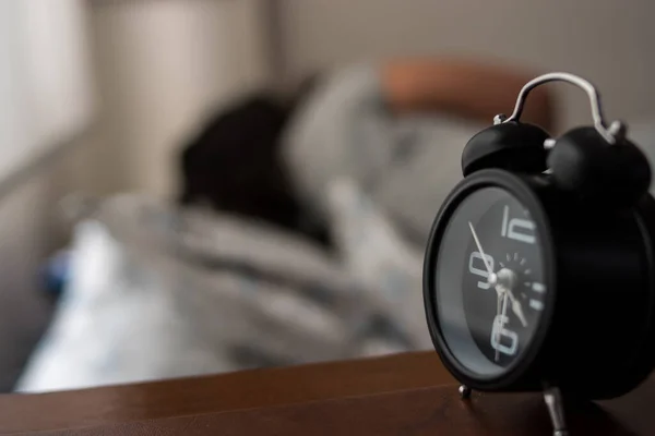 Маленький Чорний Годинник Білій Спальні Людиною Яка Спить Фоні — стокове фото