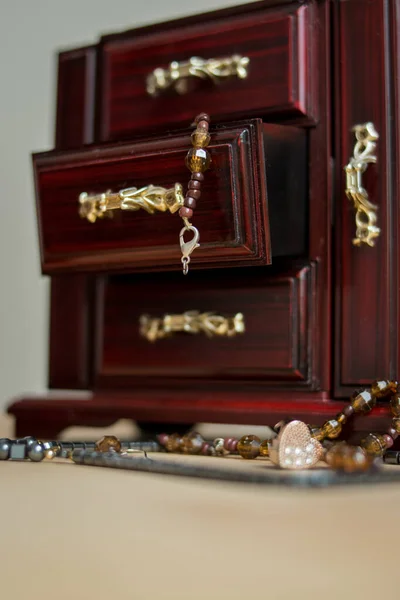 Old wooden jeweler with some jewelry on a table in a bedroom