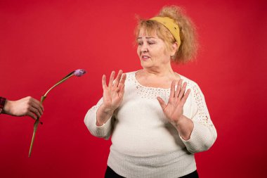 Yaşlı bir kadına bir lale verilir, ama kadın hediyeyi reddeder, çiçekten hoşlanmaz ve olumsuz duygular gösterir, kırgınlık kavramı, feminizm.