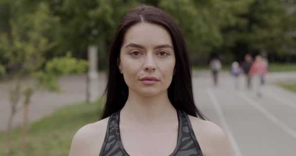 Sportowa dziewczyna z ciemnymi włosami poszła na jogging, w podróży nosi maskę medyczną, koncepcję ochrony przed wirusami — Wideo stockowe