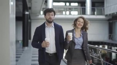 İki meslektaş iş yerinde başkalarıyla konuşmadan ve çalışmadan konuşuyor. Bir sonraki proje, takım çalışması tartışılıyor