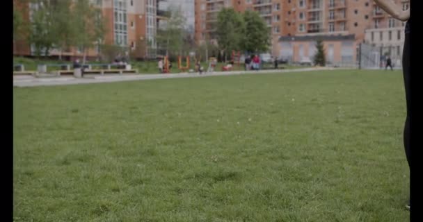 Close-up tiro, menina de tênis preto e leggings fazendo aquecimento na grama, conceito de estilo de vida saudável — Vídeo de Stock