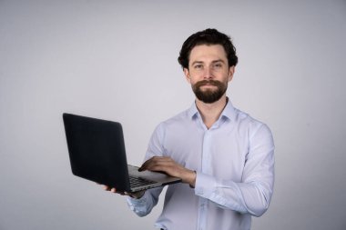 İnsan portresi, günlük kıyafetlerle dizüstü bilgisayarda çalışıyor. Beyazla izole edilmiş. İletişim kavramı.