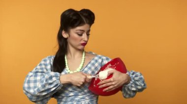 Sarı arka planda hamur pişiren tahriş olmuş ev hanımı.