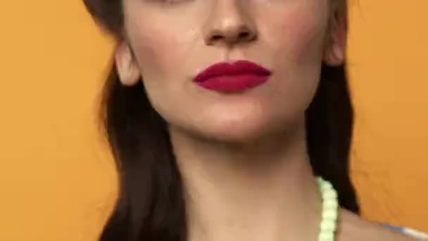 Частичный вид девушки с красными губами, облизывающей леденец с улыбкой — стоковое видео