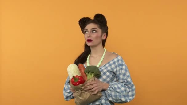 Disgustado pin-up mujer con comida vegetariana arrojando verduras — Vídeos de Stock