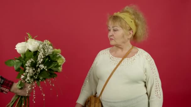 Överviktig äldre kvinna med handväska vägrar blommor — Stockvideo