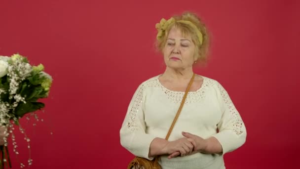 Missnöjd senior kvinna avvisa blommor och tittar bort — Stockvideo