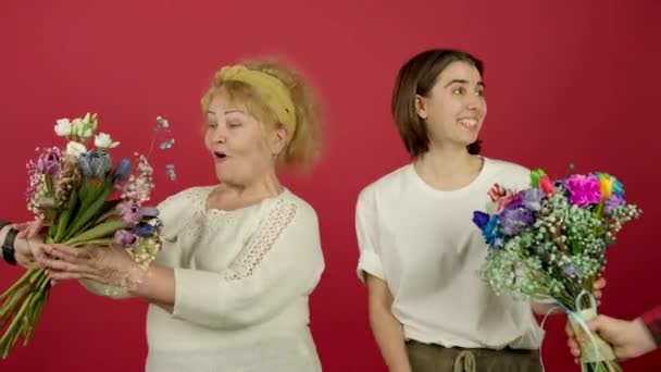 Glimlachende senior vrouw en meisje het aanvaarden van bloemen — Stockvideo