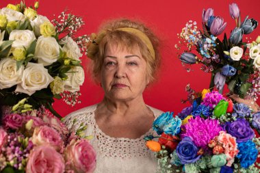 Yaşlanmış bir kadının portresi, farklı çiçeklerin etrafında, gençliğini ve geçen yılları hatırlatmak için.