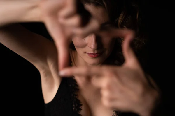 Meisje in zwart kant beha poseren voor de camera en maakt handvenster — Stockfoto