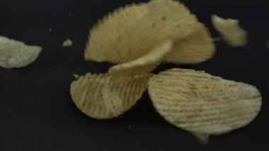 Patates cipsinin Süper Yavaş Çekimi Kara Arkaplanda Patladıktan Sonra Uçar