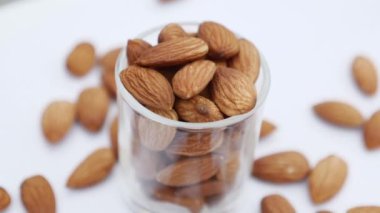 Beyaz arka planda badem. Gözlükteki bademleri yakın plan çekiyoruz. Sağlıklı diyet videosu için badem fıstığı