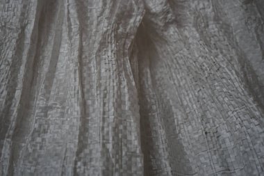 Buruşuk kumaş dokusu. Polipropilen. Yapay kumaşın kabataslak yüzeyinin dokusu. Beyaz gri grunge doku arkaplanı.