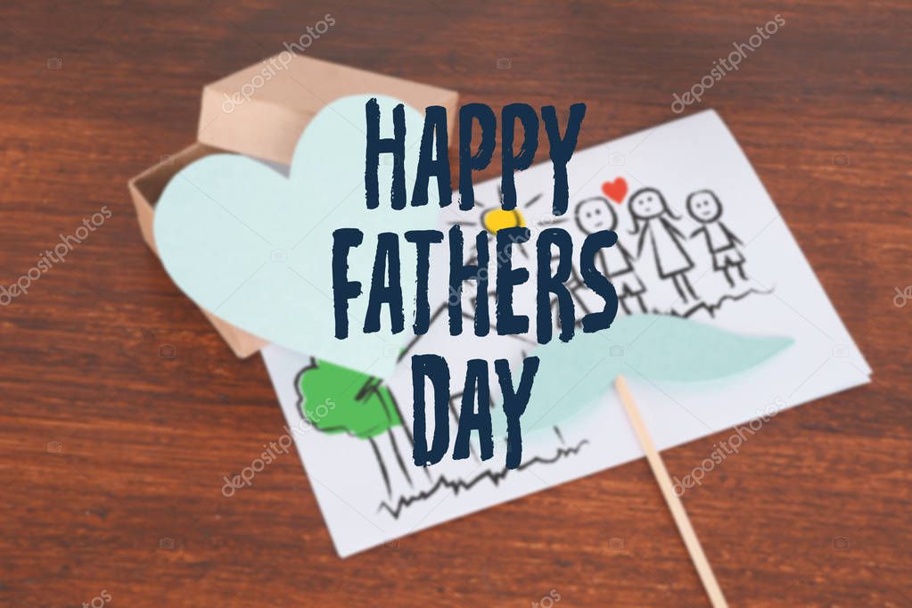 Happy Fathers Day greeting card with Photo booth props mustache and gift box on wooden background