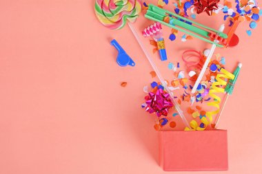 Parti konfeti, flamalar ve Borazanlar turuncu zemin üzerine kırmızı hediye kutusu. Kutlama kavramı