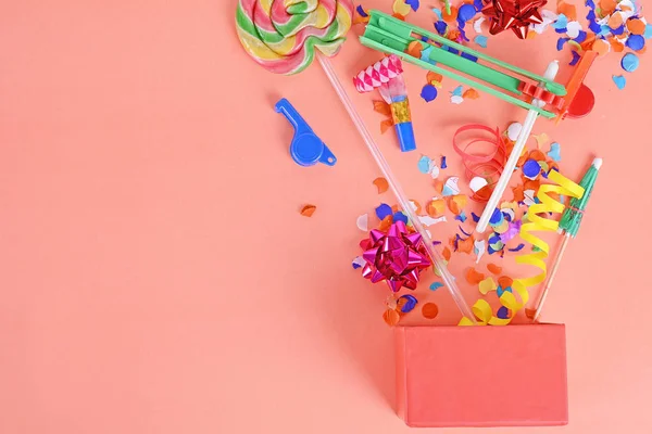 Parti konfeti, flamalar ve Borazanlar turuncu zemin üzerine kırmızı hediye kutusu. Kutlama kavramı