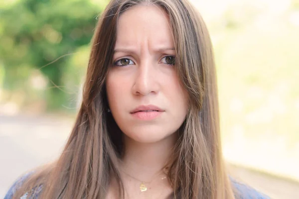 Young latin woman having uncertain and frustrated look. Outdoors. Facial expressions concept.